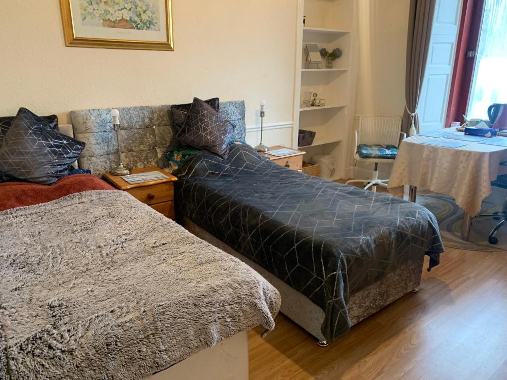 Un dormitorio con una cama, un sofá y una mesa. en Twin room close to Royal Troon free parking, en Irvine