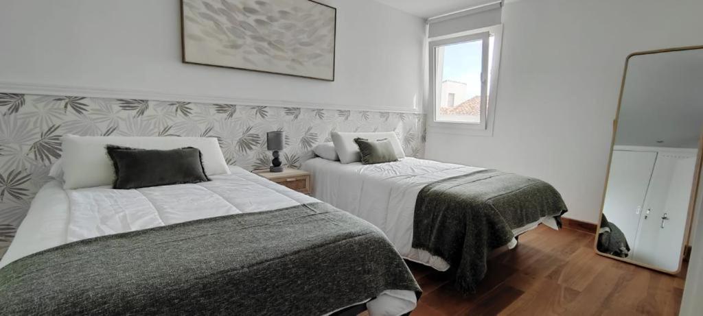 sypialnia z dwoma łóżkami i lustrem w obiekcie Puerto Banus Beach w Marbelli