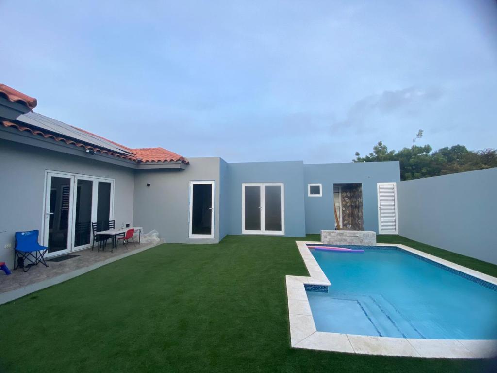 a backyard with a swimming pool and a house at Pool house in Paradera