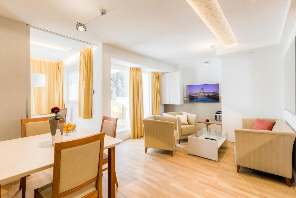 a living room with a table and a dining room at Vienna Grand Apartments DANUBE in Vienna