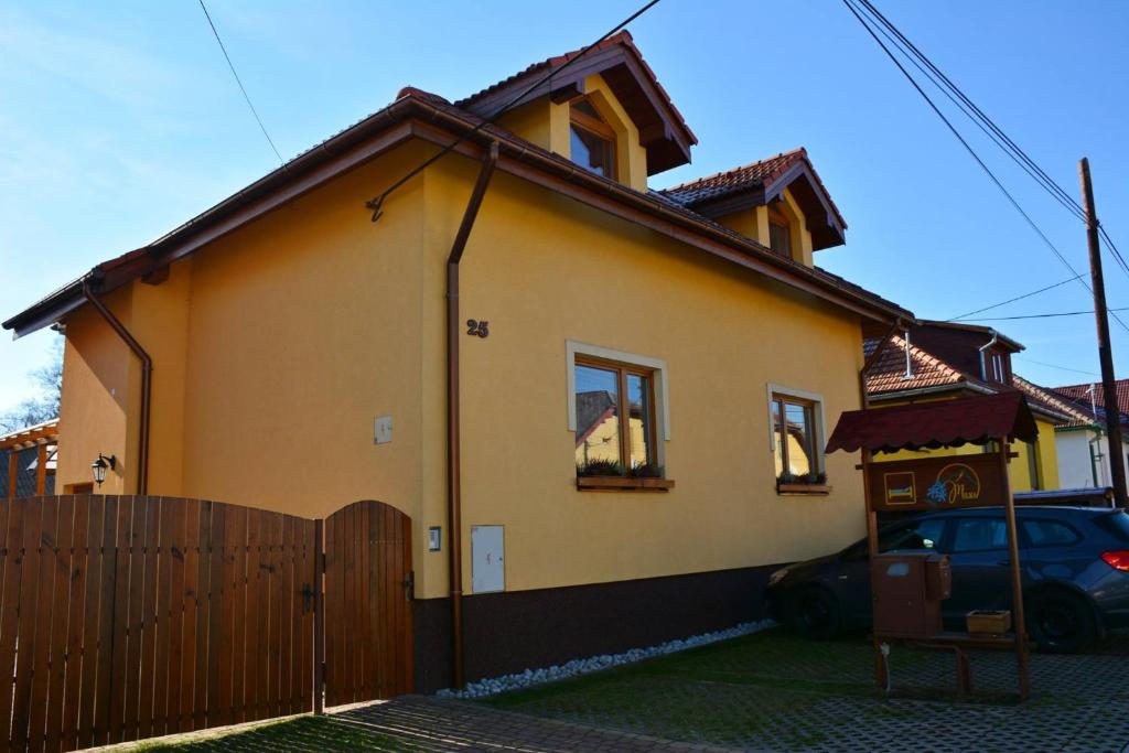 ein Haus mit einem Zaun davor in der Unterkunft Guest House Penzión Milka in Smižany