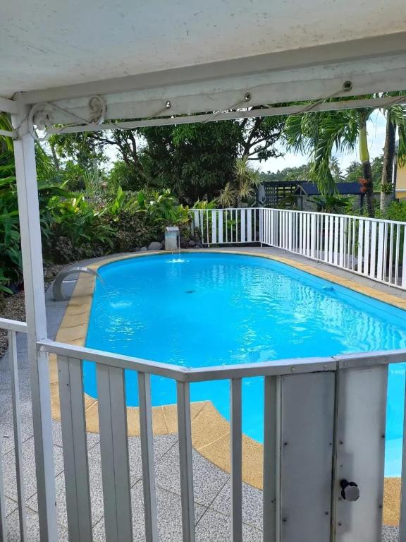 a swimming pool with a fence around it at Bungalow cosy à Sainte-Rose, piscine et vue sur jardin. in Sainte-Rose