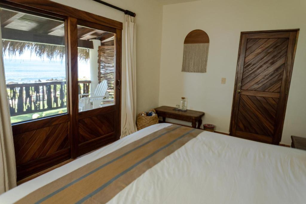 a bedroom with a bed and a large window at Casa Manzanillo - Ocean Room - Ocean View Room at Exceptional Beach Front Location in Troncones