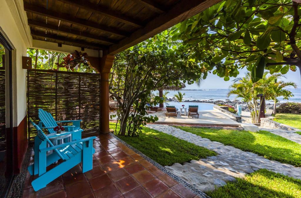 a porch with a blue bench and a view of the ocean at Casa Manzanillo - Sunset Room - Ocean Front Room at Exceptional Beach Front Location in Troncones