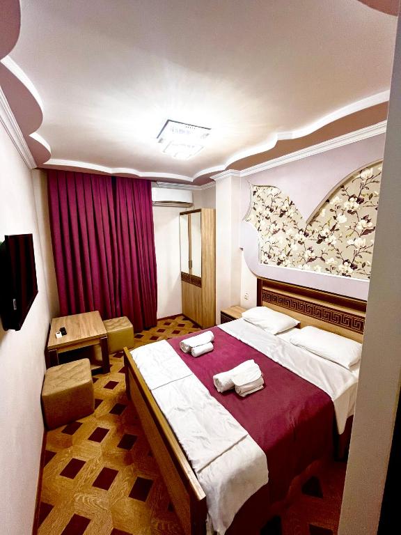 a hotel room with a large bed with red sheets at Georgian Palace Hotel in Kutaisi
