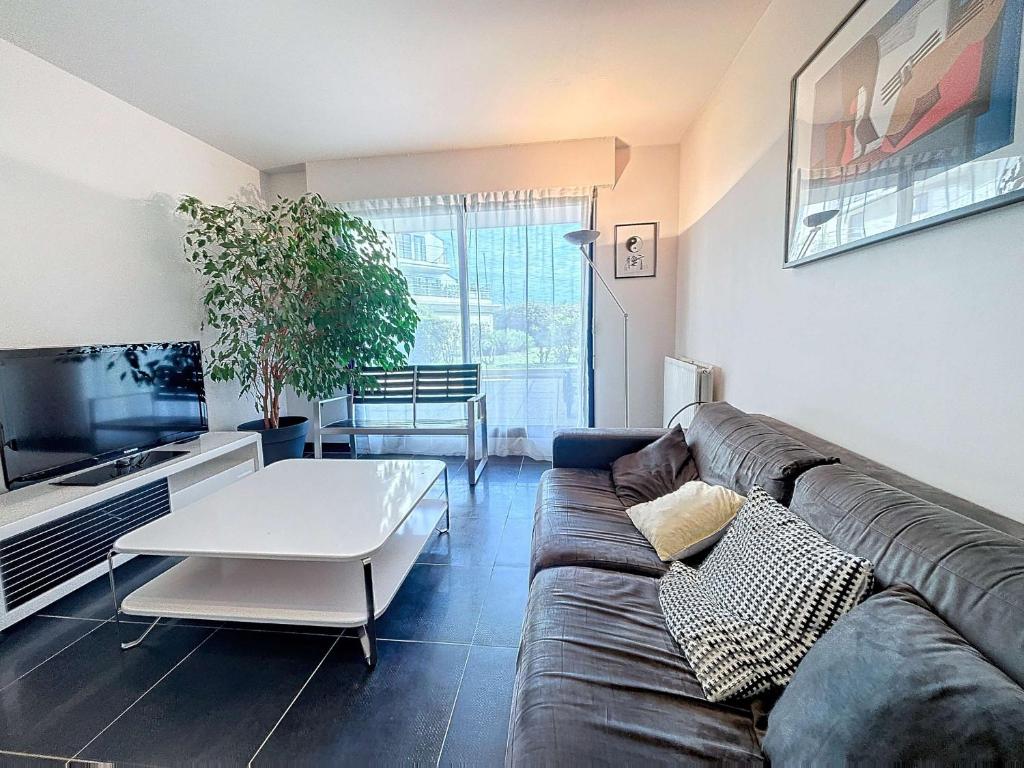 a living room with a couch and a table at Appartement moderne avec terrasse et parking, au cœur de Granville, à deux pas de la plage ! - FR-1-361-77 in Granville