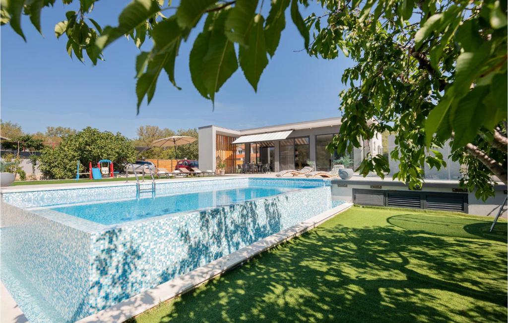 a swimming pool in front of a house at Gorgeous Home In Katuni With Wifi in Katuni
