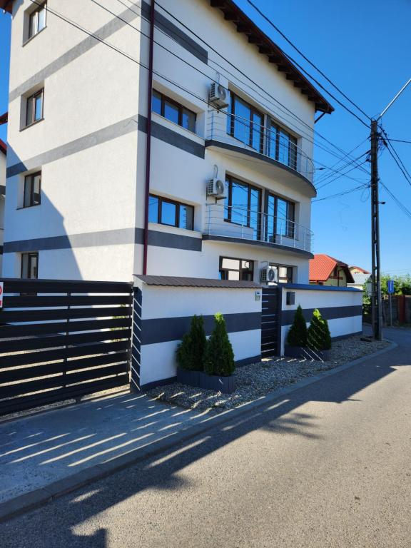 a white building with trees in front of it at Casa BID in Piteşti