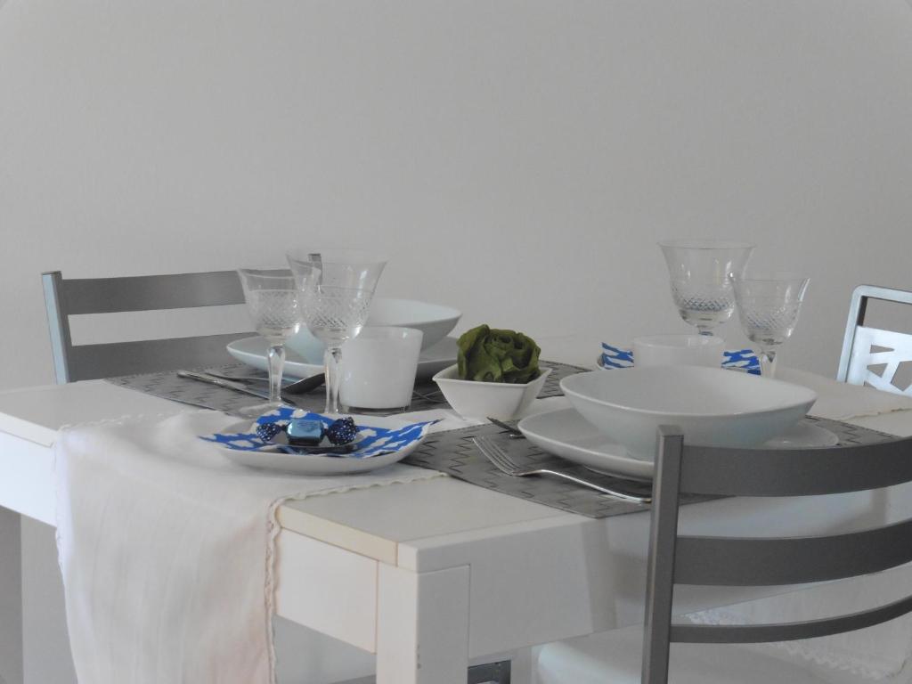 ウーディネにあるAppartamento Artの白いテーブル(白皿、メガネ付)