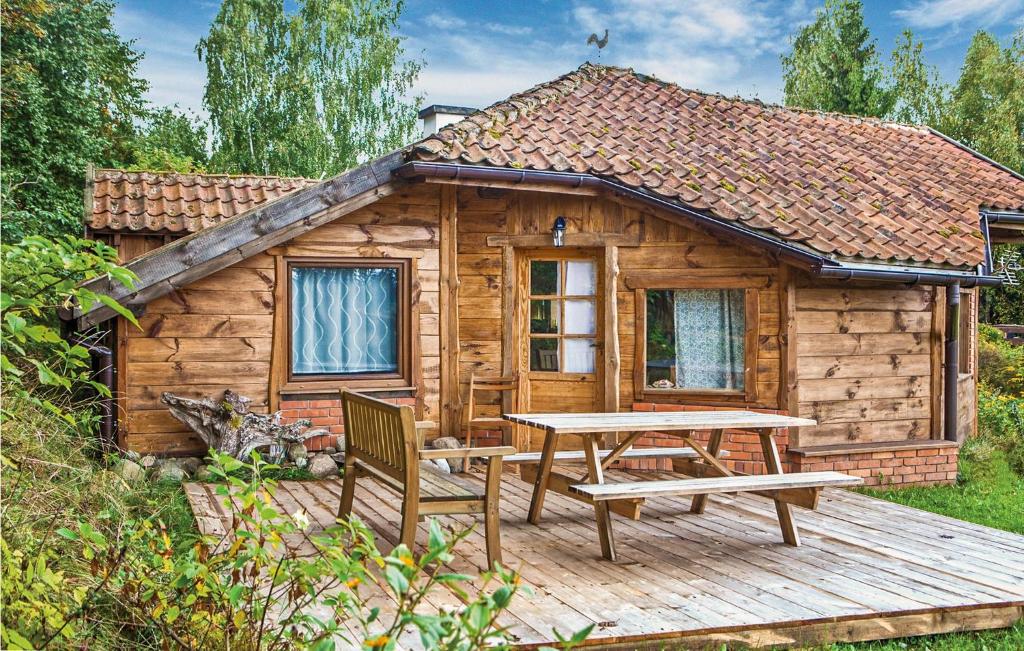 a wooden cabin with a table and a picnic table at Three-Bedroom Holiday Home In Milakowo in Miłakowo