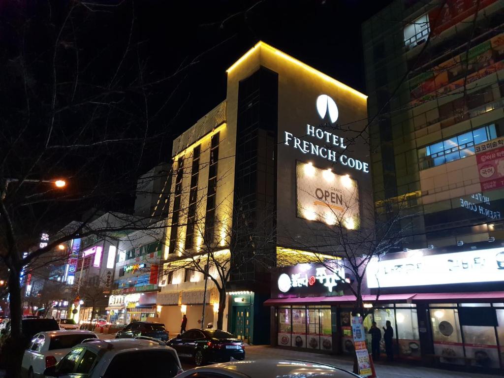 a hotel french cove building on a city street at night at Hotel French code Myeongji in Busan