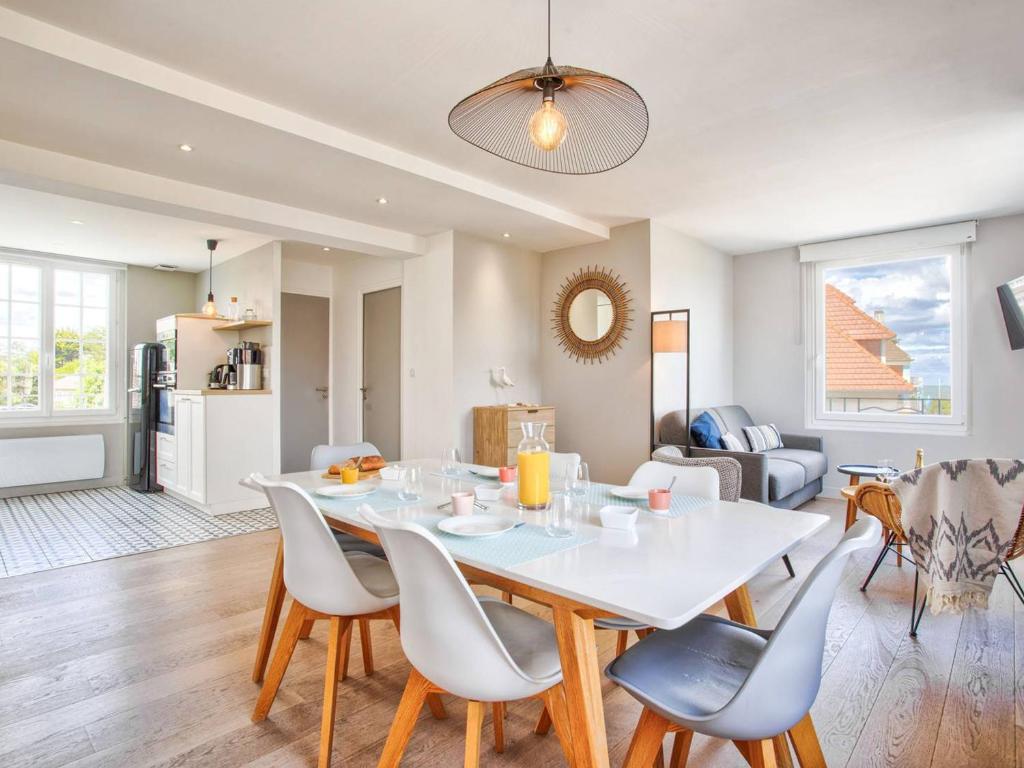 une salle à manger et un salon avec une table et des chaises dans l'établissement Appartement en centre-ville de Merville Franceville avec cuisine équipée - FR-1-788-19, à Merville-Franceville-Plage