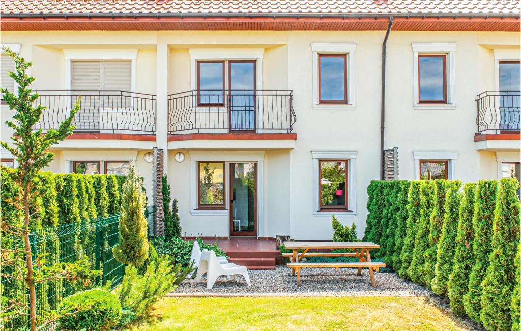 una casa con una panchina davanti di Cozy Home In Mielno With Kitchen a Mielno