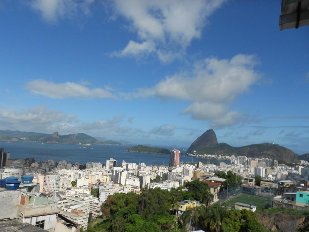 uitzicht op een stad met bergen en de oceaan bij Hostel Tavares Bastos in Rio de Janeiro