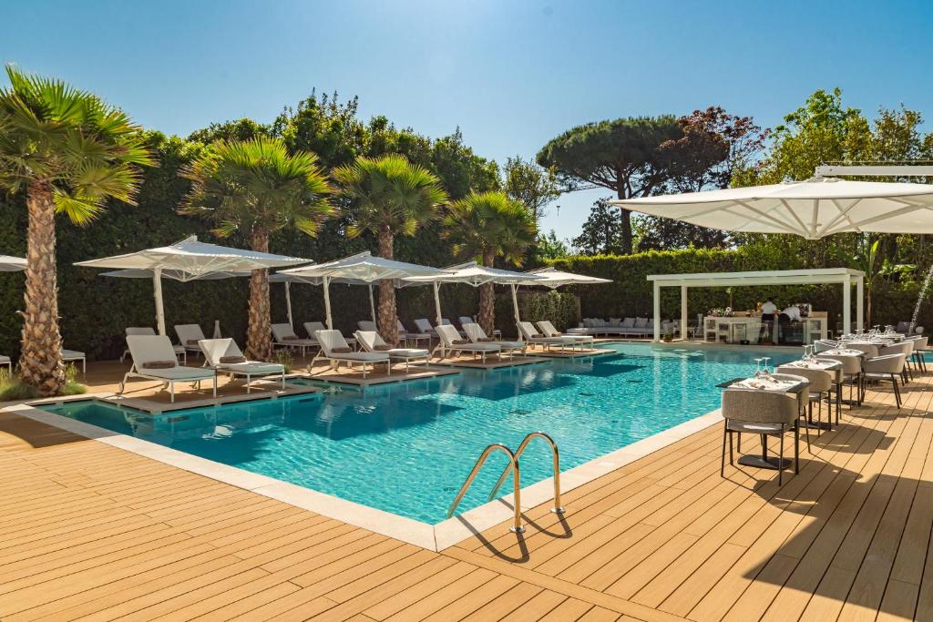 a swimming pool with lounge chairs and umbrellas at Resort Miramonti in Forte dei Marmi