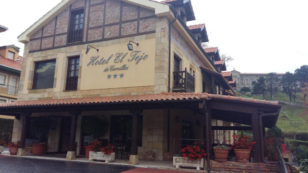 a building with a sign on the front of it at El Tejo de Comillas in Comillas