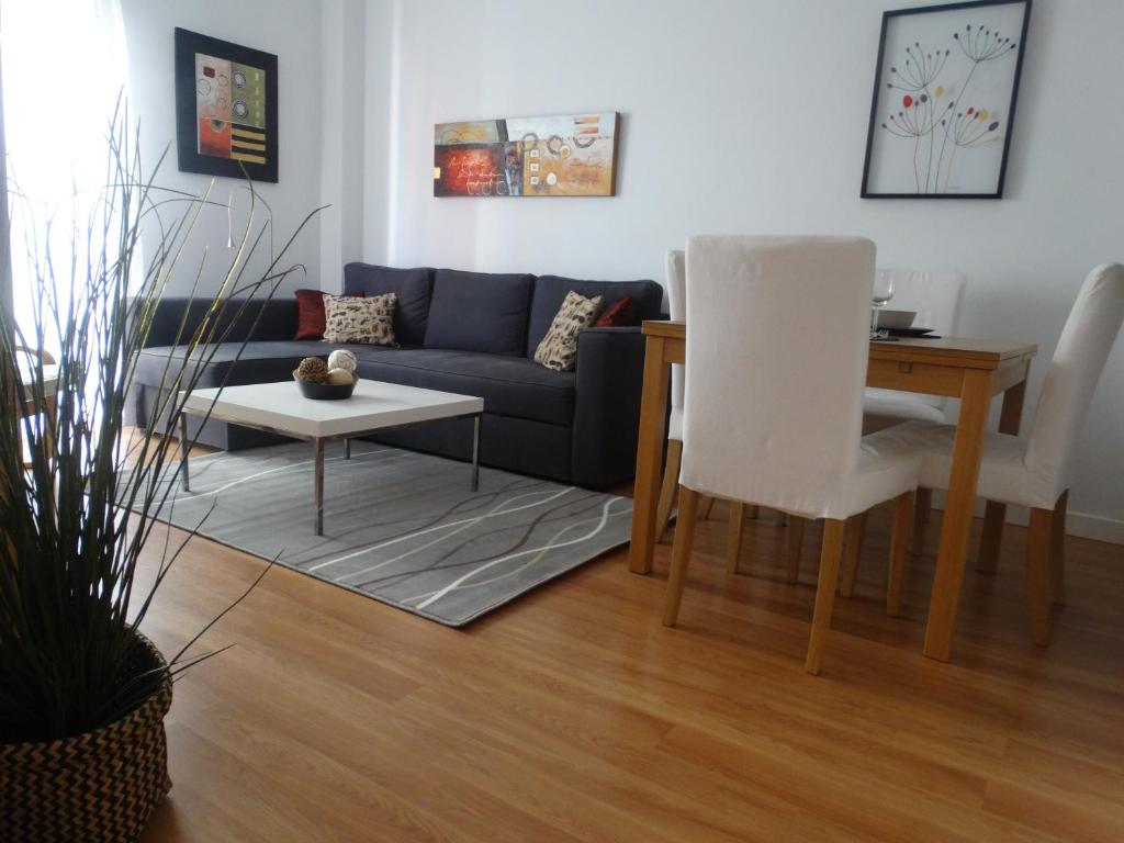 sala de estar con sofá y mesa en Málaga Apartamentos - Montaño, 18, en Málaga