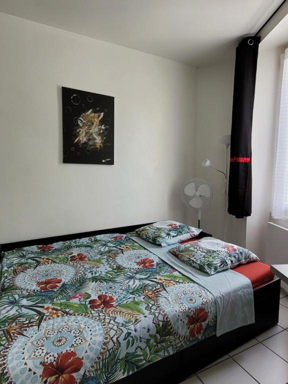 une chambre avec un lit avec une couette colorée dans l'établissement Studio Buffon, à Avignon