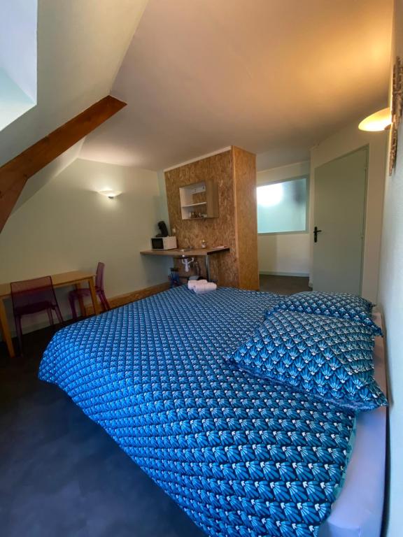 - une chambre avec un grand lit bleu dans l'établissement studio 3- les moulins, à Cherbourg en Cotentin