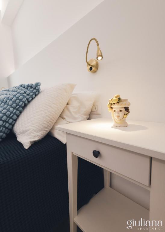 a bedroom with a bed and a table with a mirror at Giuliana in Letojanni