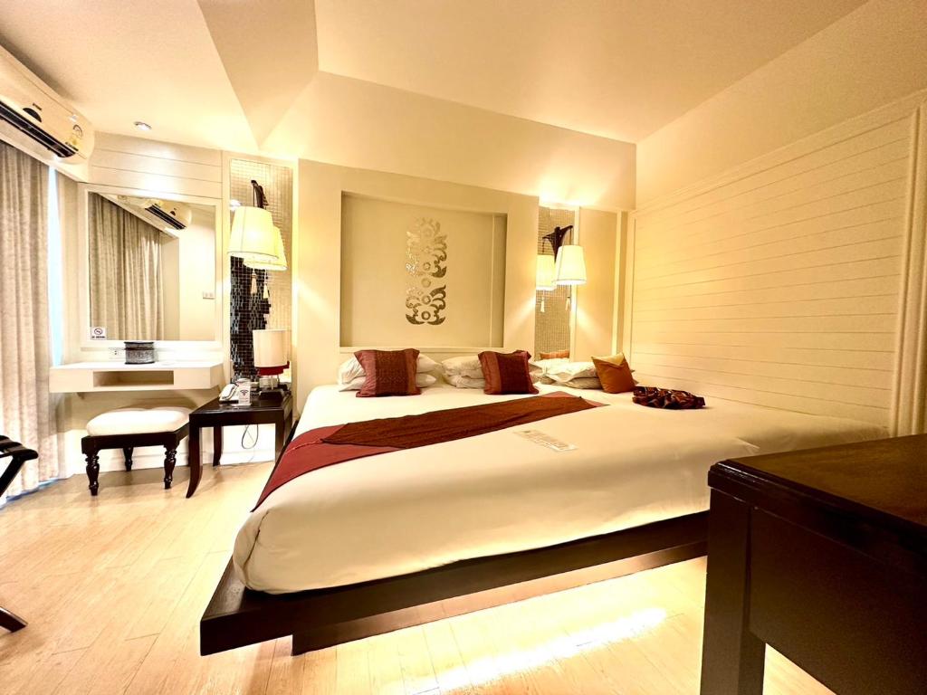 a large bedroom with a large bed and a desk at Chiangmai Gate Hotel in Chiang Mai