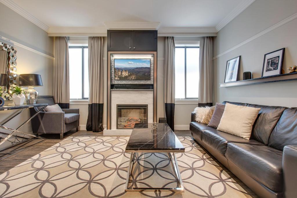 a living room with a couch and a fireplace at Family Retreat In Top Blue Mountains Location in Katoomba