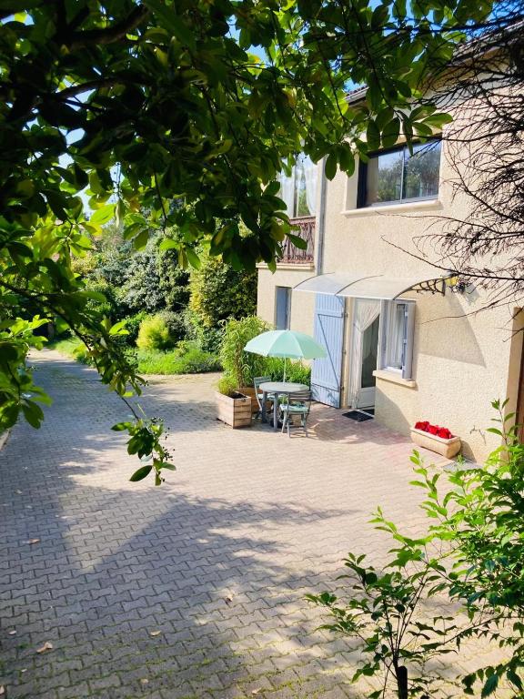 une terrasse avec une table et un parasol en face d'un bâtiment dans l'établissement La Petite Noix, à Sarlat-la-Canéda