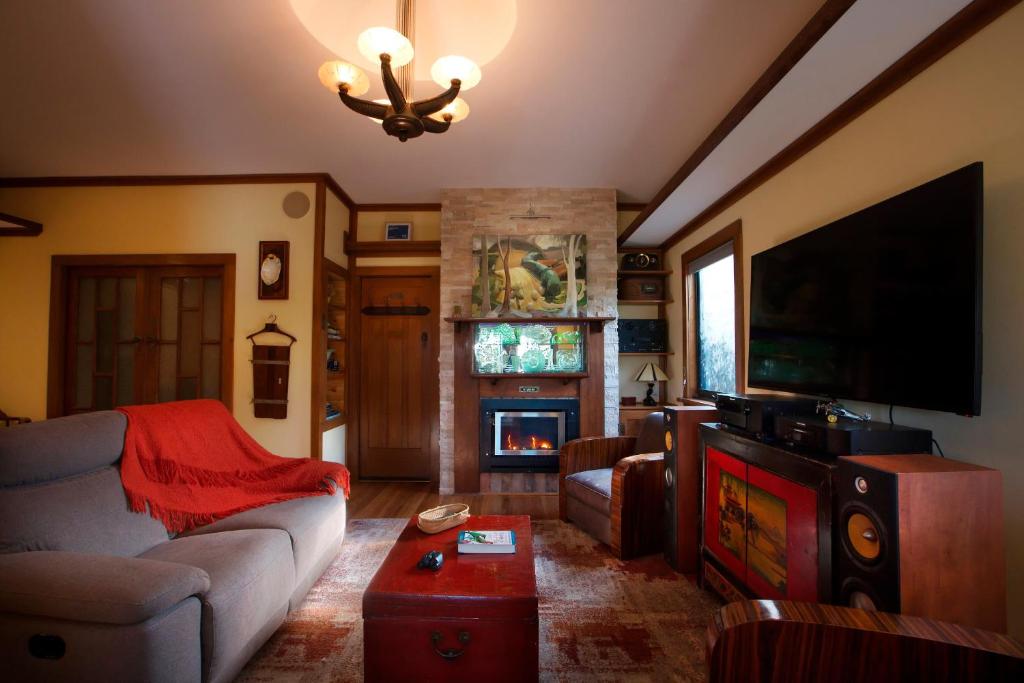 a living room with a couch and a tv and a fireplace at Shiloh Station House in Franklinford