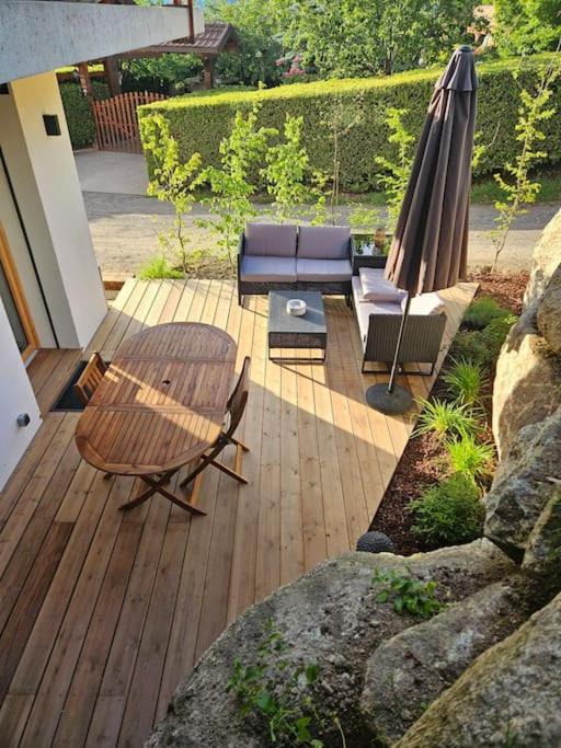 une terrasse avec une table, un canapé et un parasol dans l'établissement Charmant T1 montagnard proche parc thermal, à Saint-Gervais-les-Bains