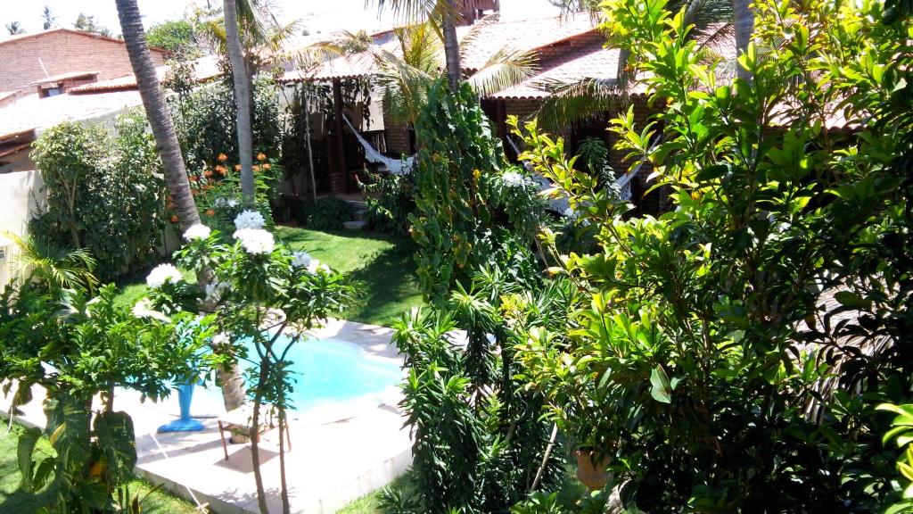 um jardim com piscina e árvores e uma casa em Butterfly House em Flecheiras