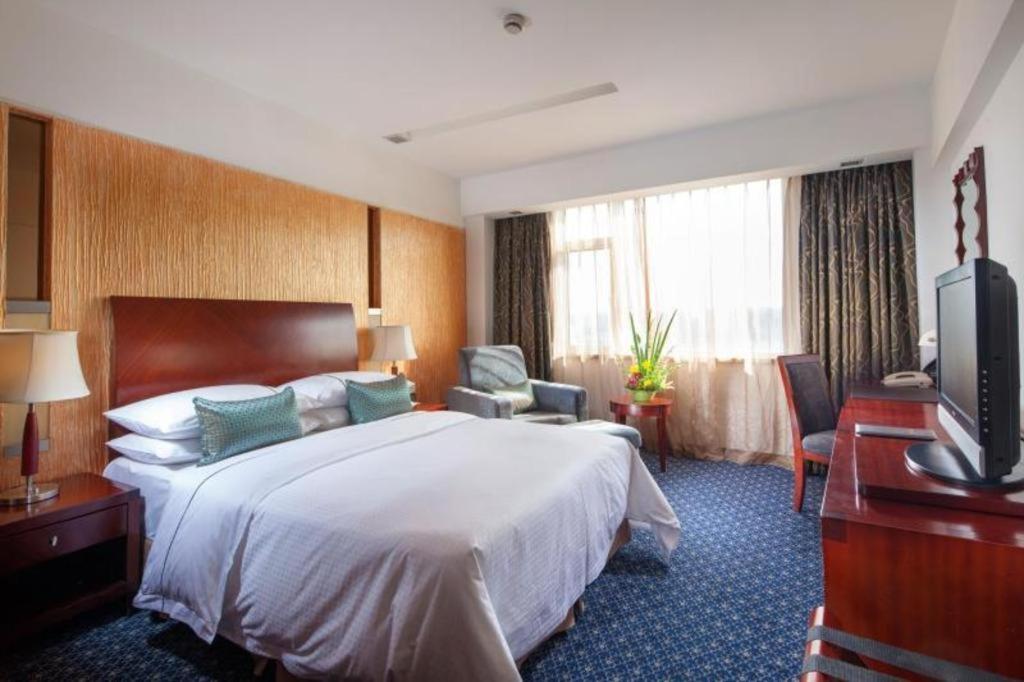 a hotel room with a bed and a television at Argyle International Airport Hotel Shanghai in Shanghai