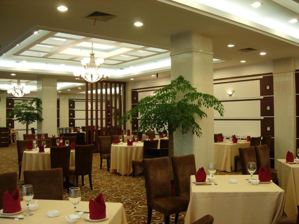 a dining room with tables and chairs with red bows at Argyle International Airport Hotel Shanghai in Shanghai