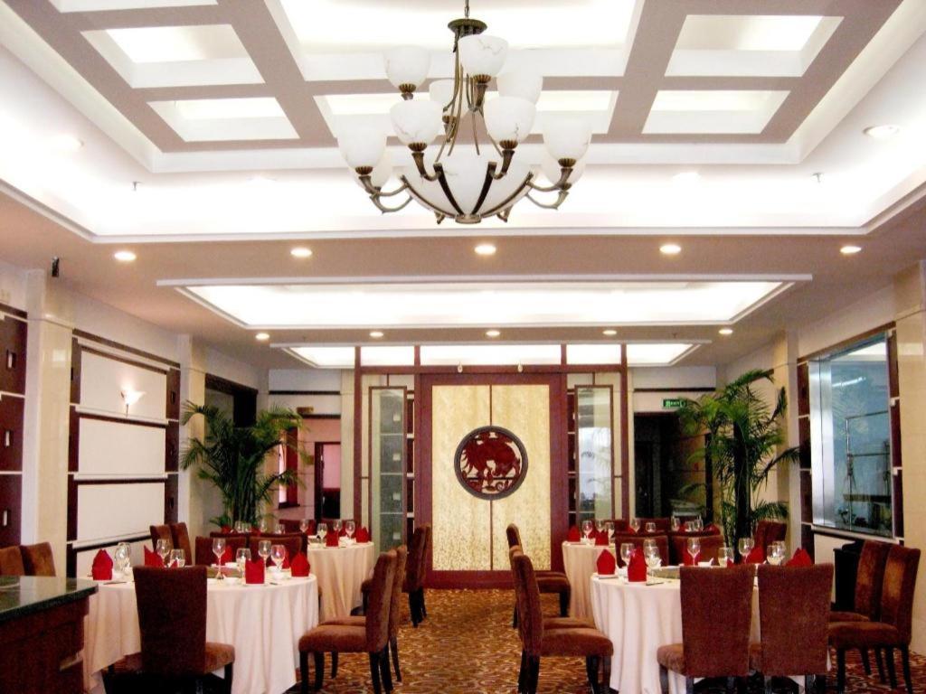 a banquet hall with tables and chairs and a chandelier at Argyle International Airport Hotel Shanghai in Shanghai