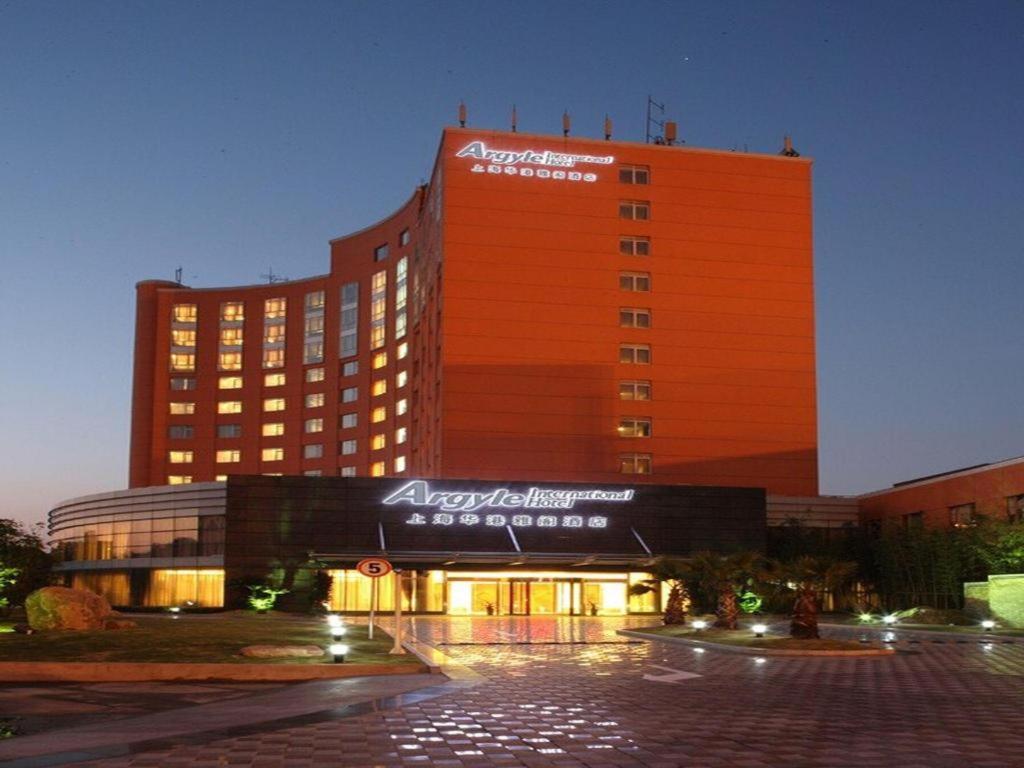 a large building with an orange facade with a sign on it at Argyle International Airport Hotel Shanghai in Shanghai