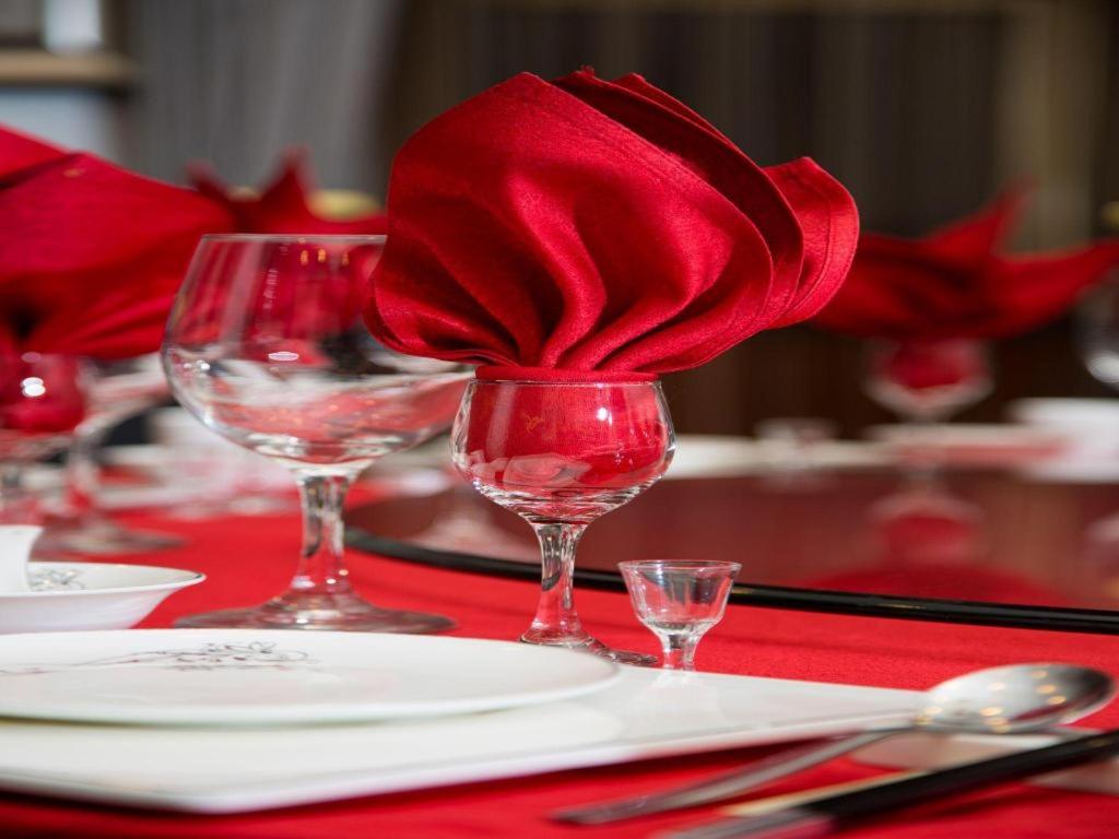 a red napkin in a wine glass on a table at Argyle International Airport Hotel Shanghai in Shanghai