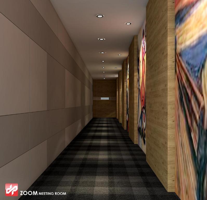 a hallway in a building with paintings on the walls at Zoom Dharmahusada Hotel in Surabaya