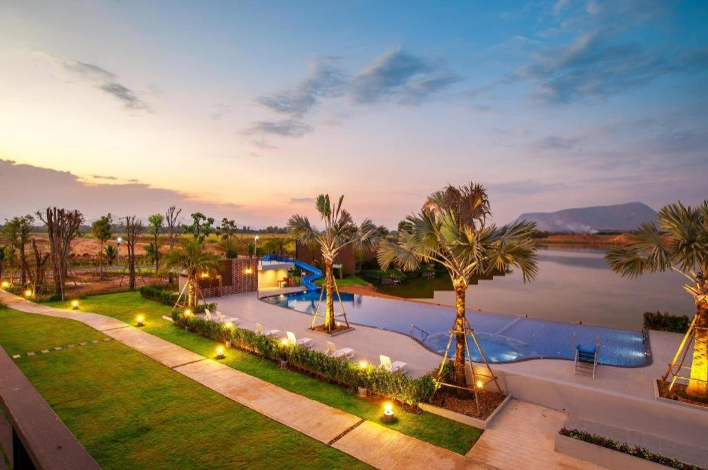 una vista aerea di una piscina con palme di Montoro Resort @Nongyaplong a Phetchaburi