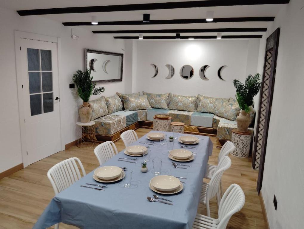 a dining room with a blue table and white chairs at La BUHARDILLA DE CHARLIN in Casas de Ves