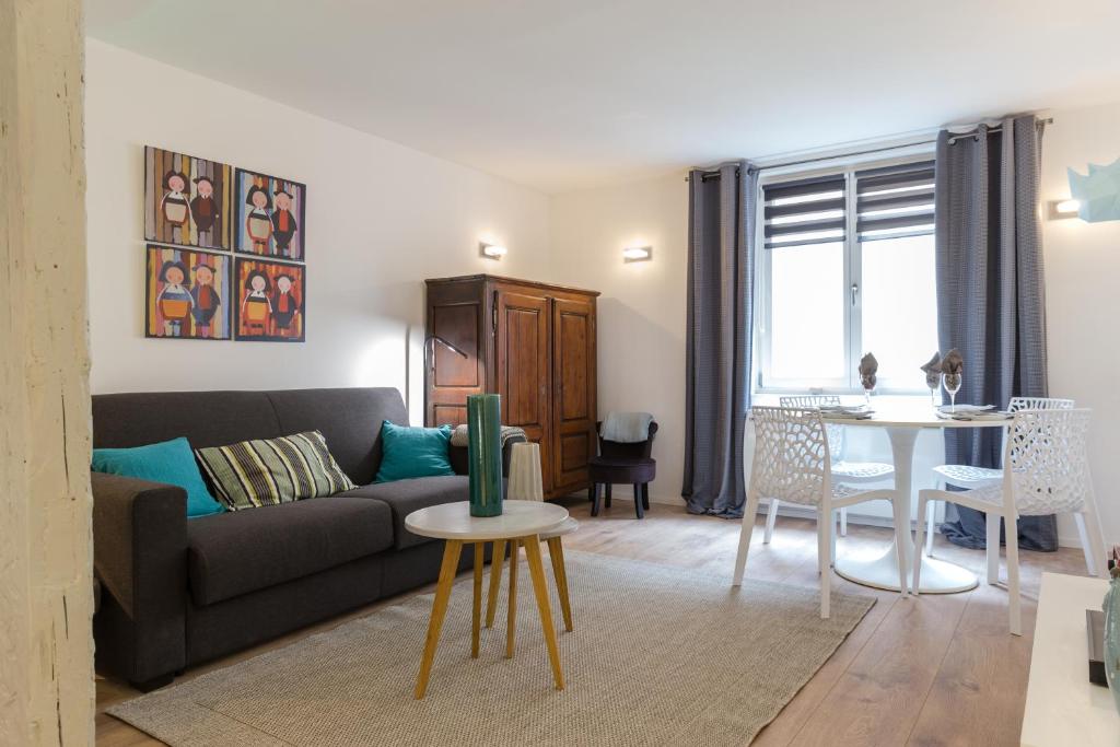 a living room with a couch and a table at Grand studio Colmar Centre in Colmar