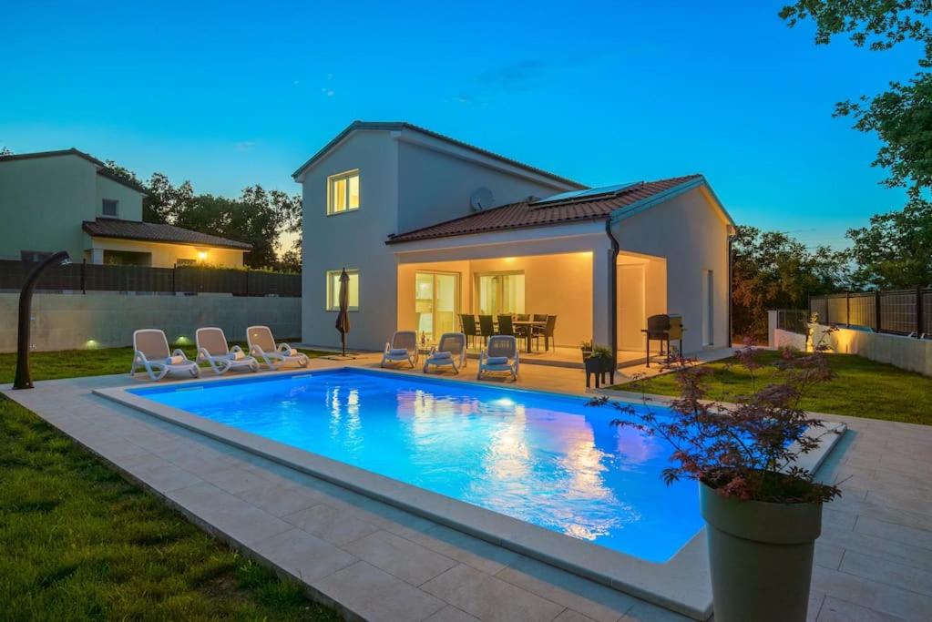 a swimming pool in front of a house at Villa Putina by IstriaLux in Svetvinčenat