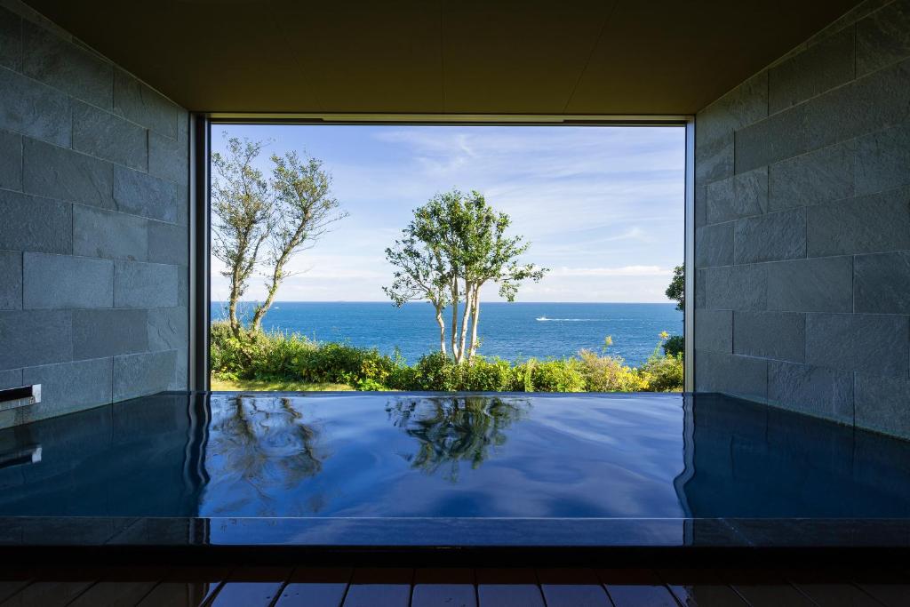 a view of the ocean from a swimming pool at Oyado The Earth in Toba