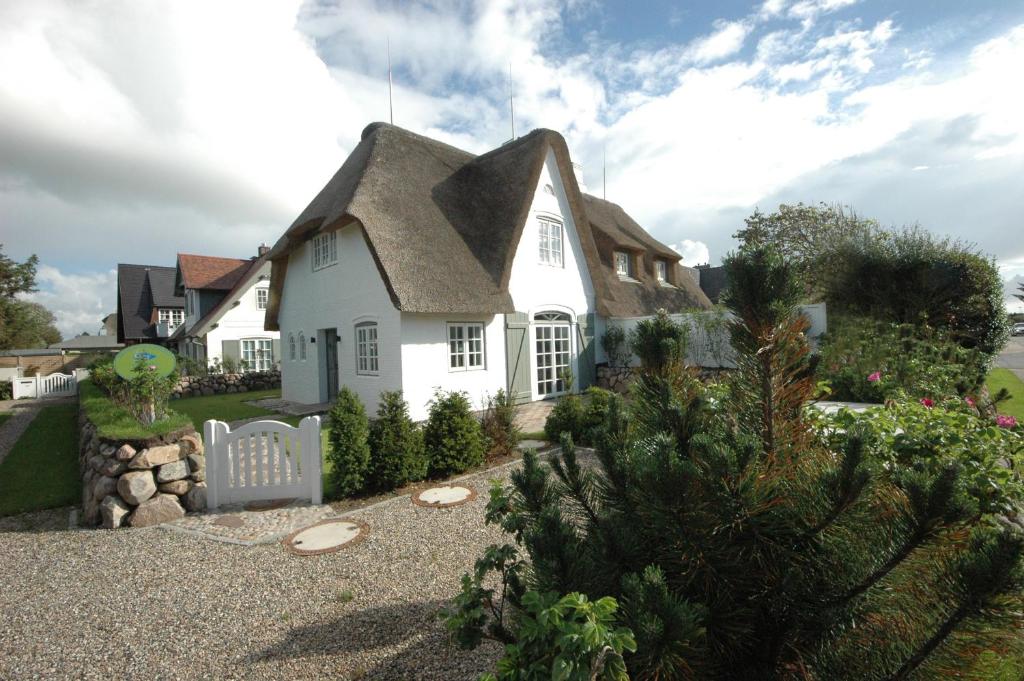 ein weißes Haus mit einem Spitzdach in der Unterkunft Landhaus Strandhafer HT 1 in Wenningstedt-Braderup