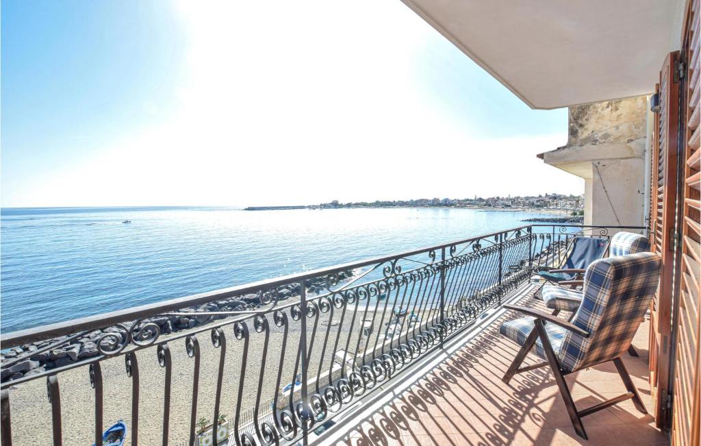 balkon z krzesłami i widokiem na wodę w obiekcie Amazing Apartment In Giardini Naxos w mieście Giardini Naxos