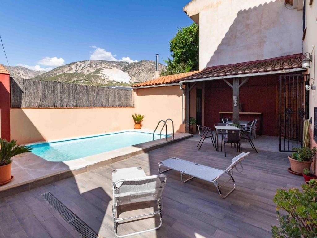 a patio with a pool and a table and chairs at Casa La Palmera in Dúrcal
