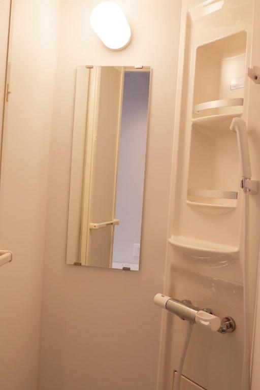 a bathroom with a mirror and a sink at HOTEL KANALOA in Tokashiki