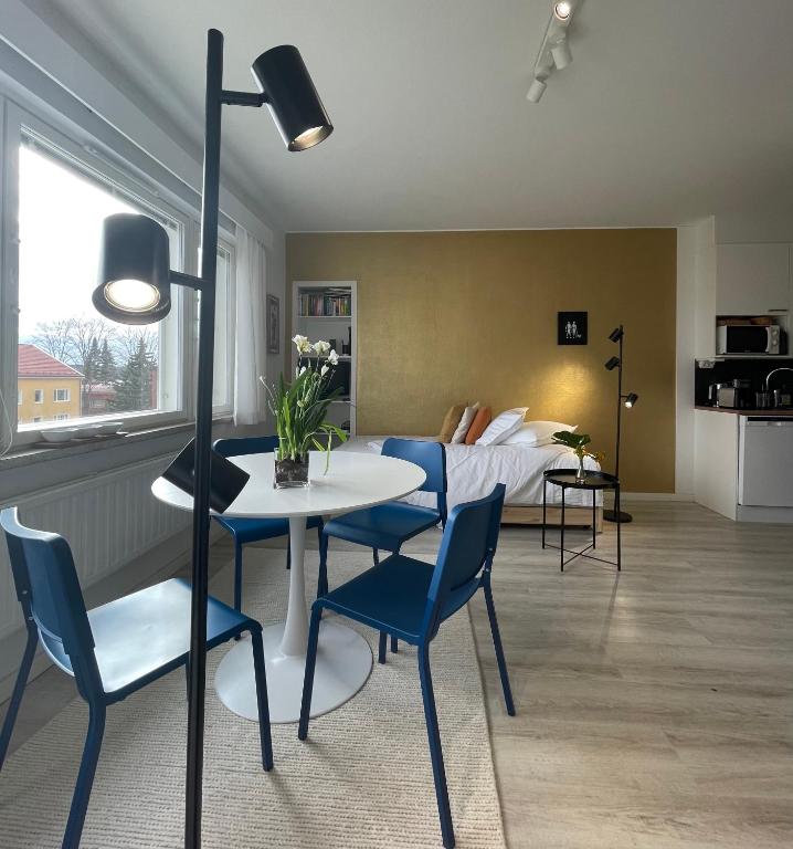 a living room with a table and chairs and a bed at Studio korttelin päässä Olavinlinnasta in Savonlinna