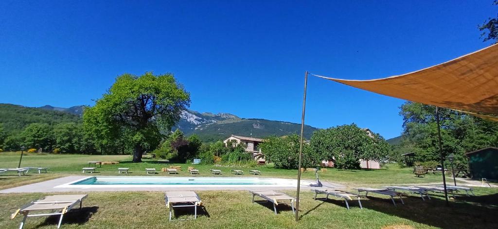 a swimming pool in a field with mountains in the background at Antica Dimora in Sarnano