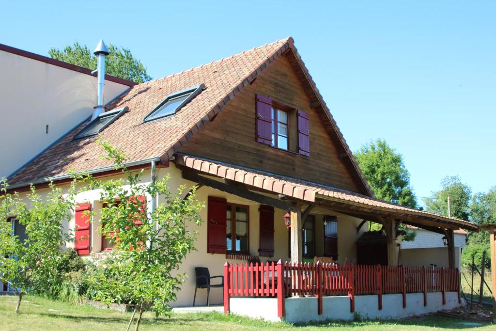 uma casa com uma cerca vermelha em frente em La Bergerie du festel em Saint-Riquier