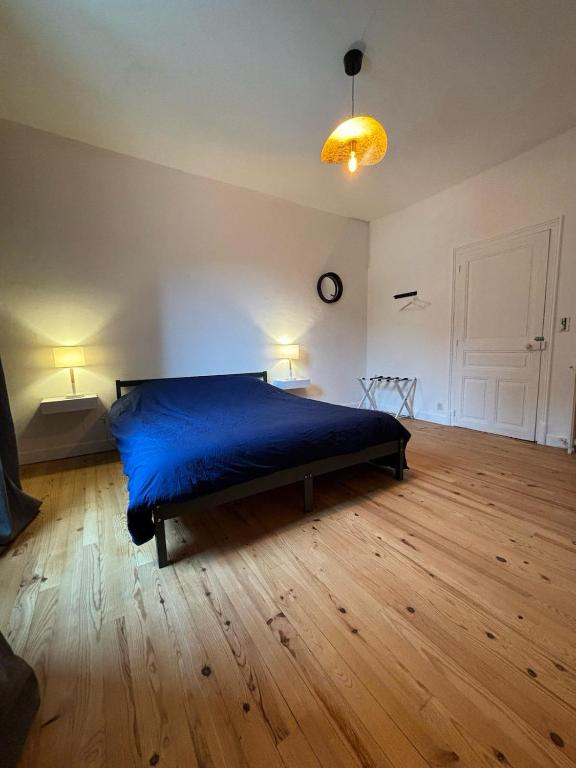- une chambre avec un lit bleu dans une pièce dotée de parquet dans l'établissement l'étape DECAZEVILLE, à Decazeville