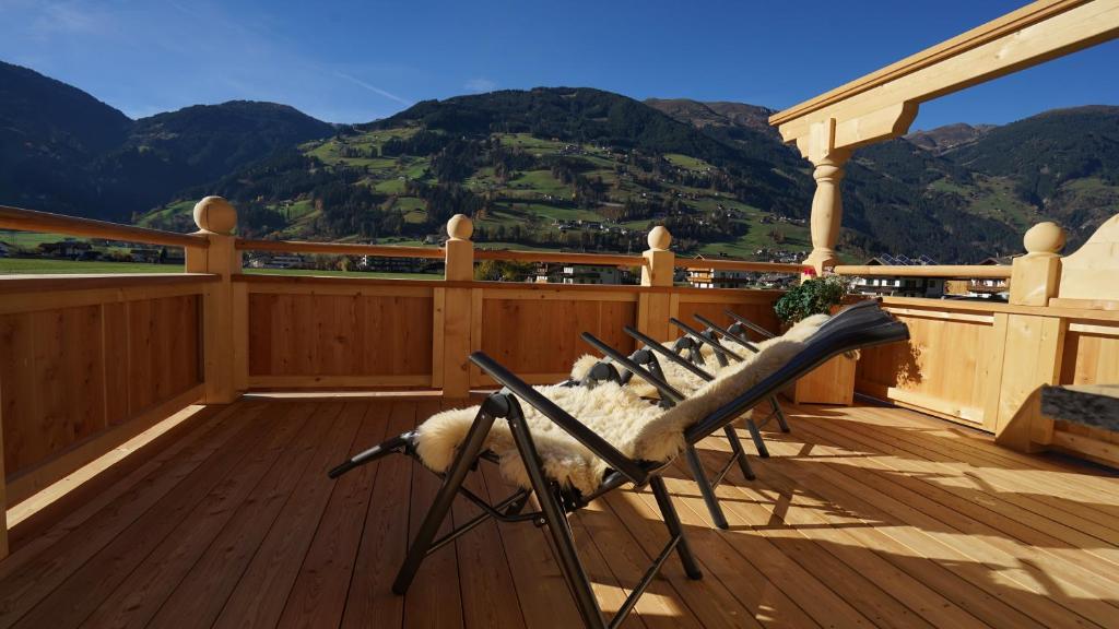 a chair on a deck with a view of mountains at Appartement Sonnenschein in Ramsau im Zillertal